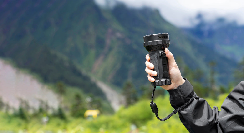 Olight Marauder 3 Black handheld outdoors in the mountains
