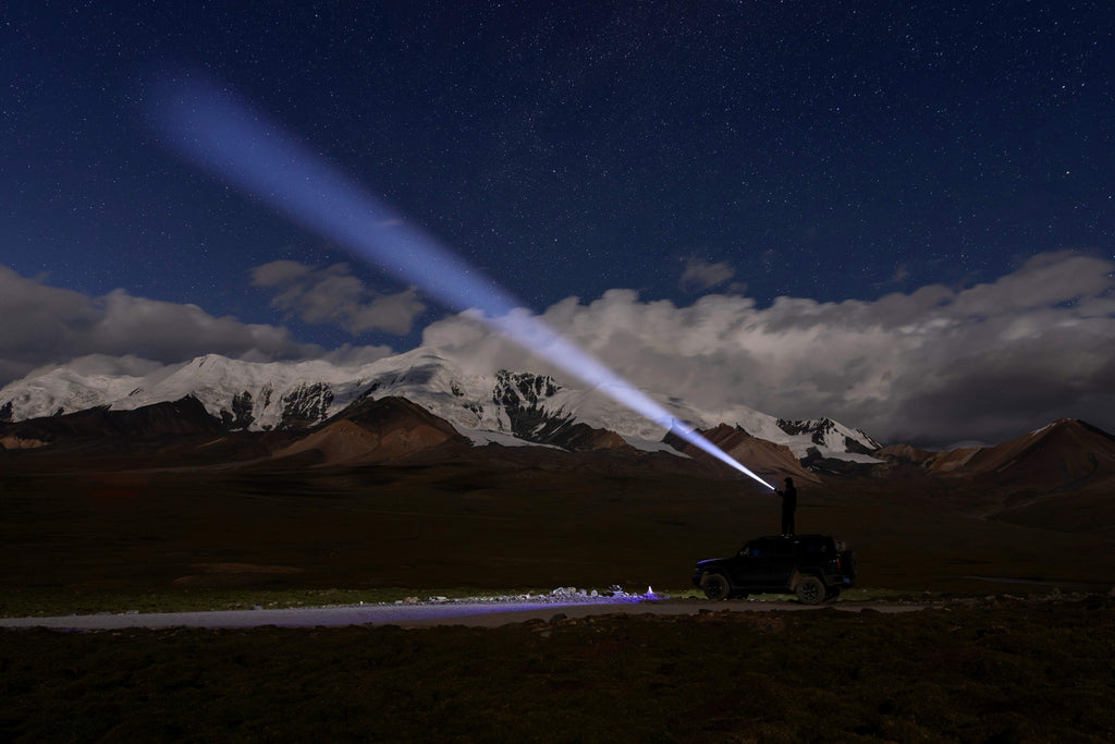 Olight Marauder 3 long-range spotlight beam across a mountain landscape at night