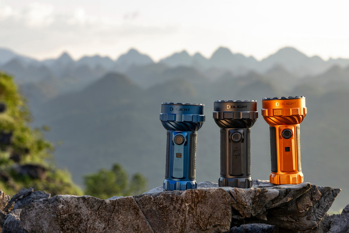 Olight Marauder 3 in Midnight Blue, Black and Orange on a mountain overlook