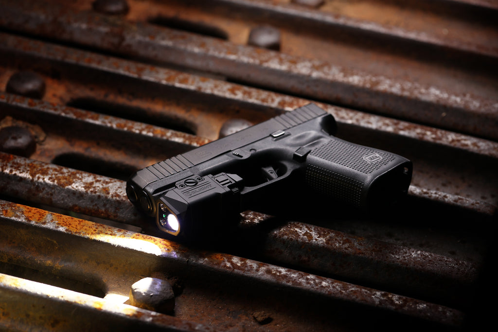 Olight PL X GL mounted on a handgun in an outdoor product lifestyle scene