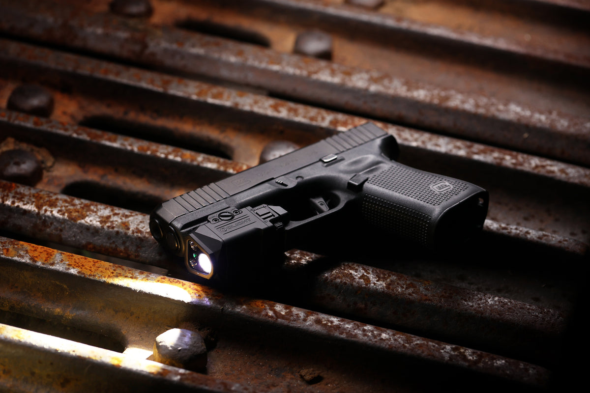 Olight PL X GL mounted on a handgun in an outdoor product lifestyle scene